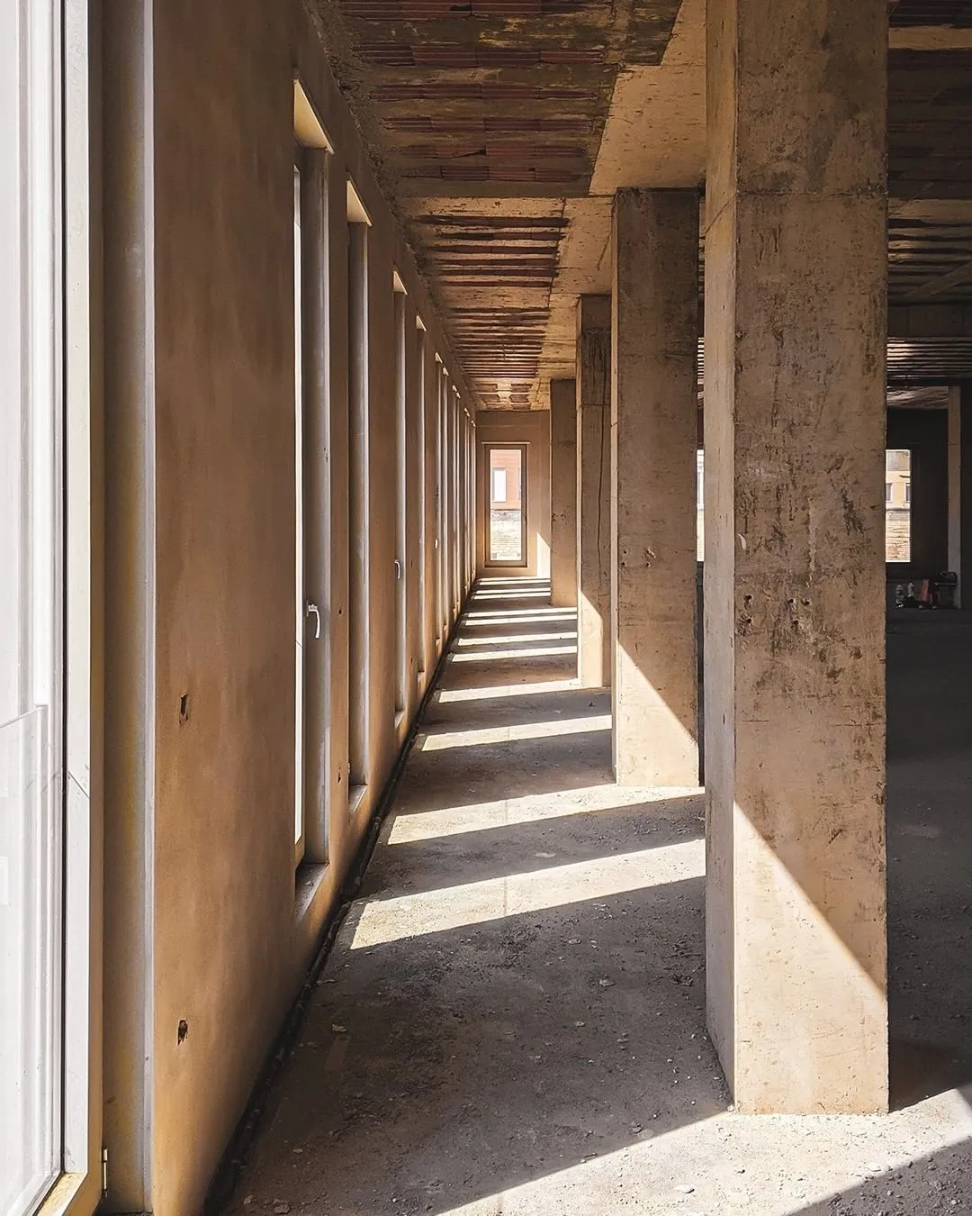 Long corridor with concrete columns and natural light